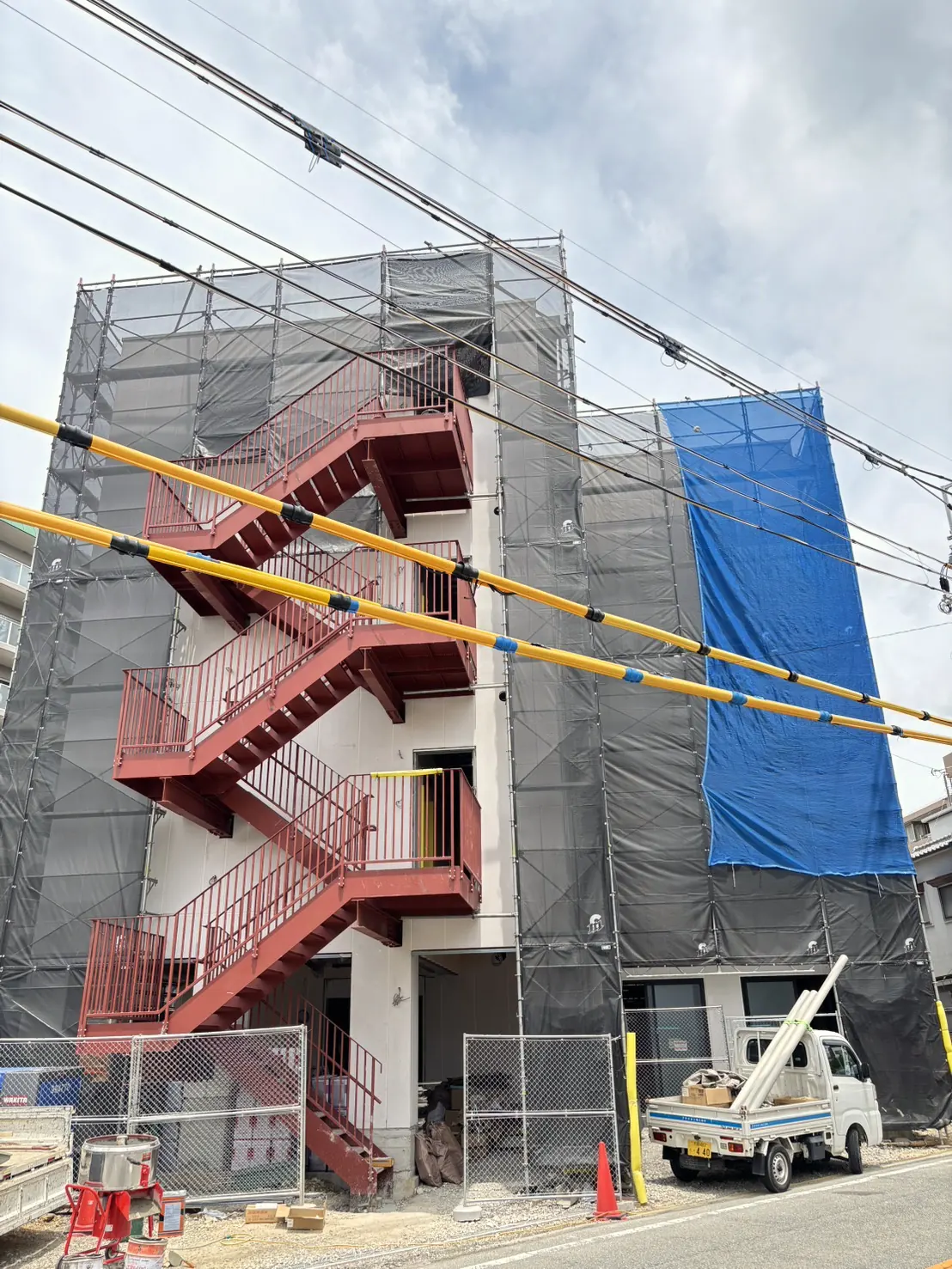 施工中の建物。足場を組み、メッシュシートで全面を養生している